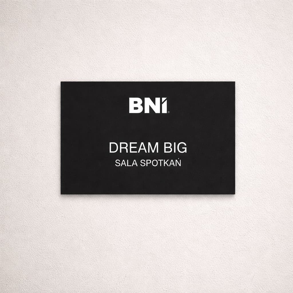 Czarna tabliczka na drzwi sali spotkań z logo BNI i białym grawerem