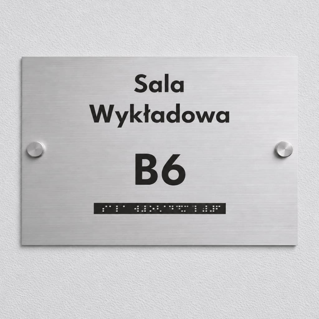 Srebrna tabliczka na drzwi do szkoły z czarnym grawerem, napisem Sala wykładowa B6 i zapisem Braille'a