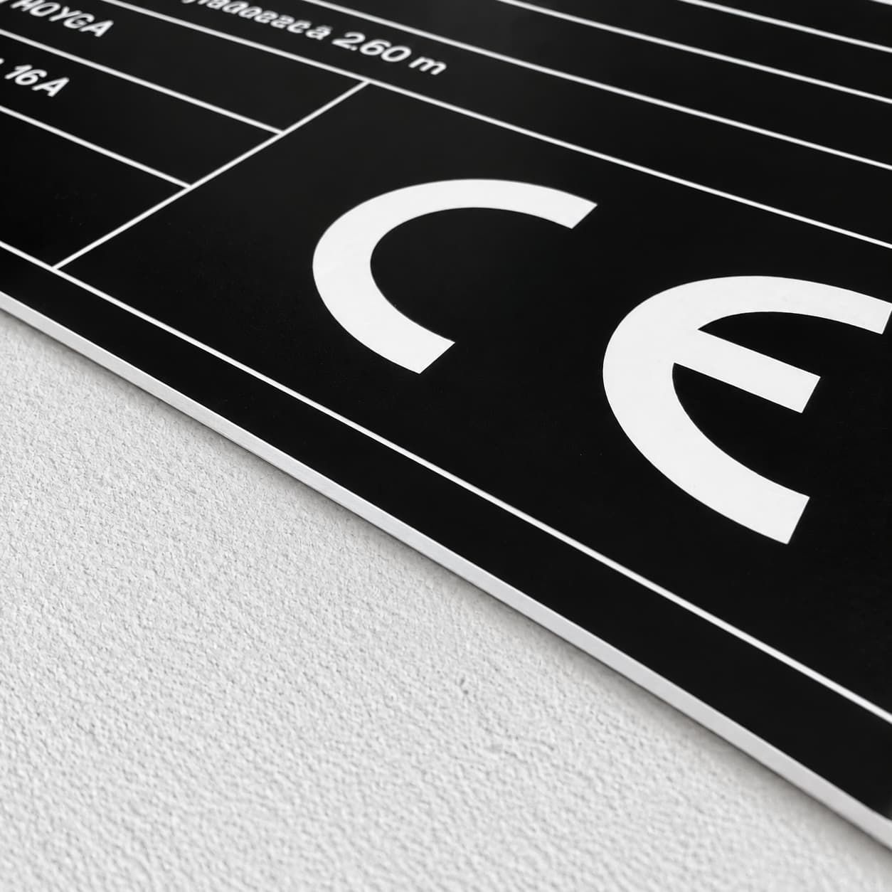 Zbliżenie czarnej tabliczki opisowej z danymi technicznymi i znakiem CE