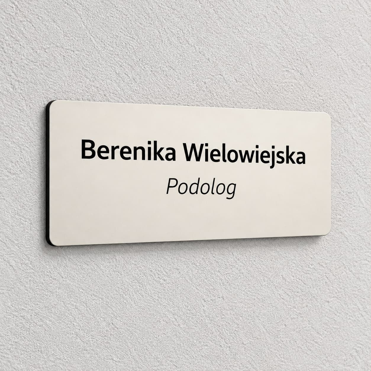 Migdałowa tabliczka na drzwi gabinetu podologa z imieniem, nazwiskiem i czarnym grawerem