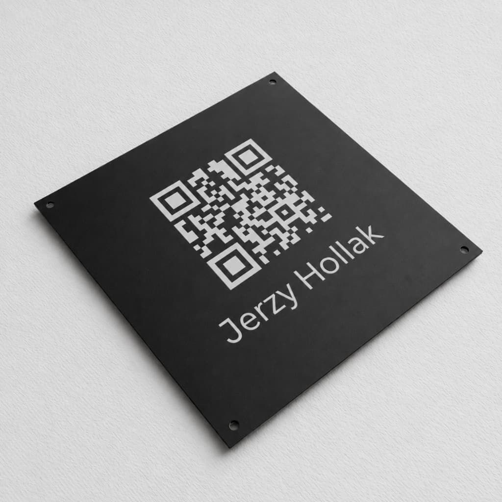 Czarna kwadratowa tabliczka z kodem QR i nazwiskiem, z otworami montażowymi