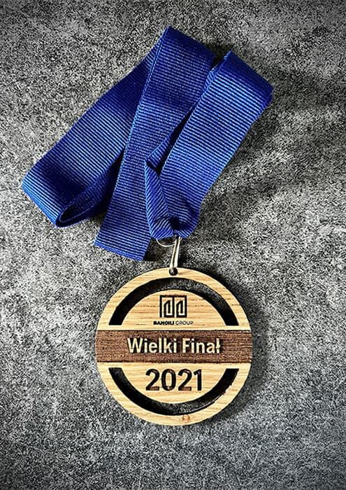 Medale drewniane okrągłe z niebieską taśmą na Wielki Finał 2021.