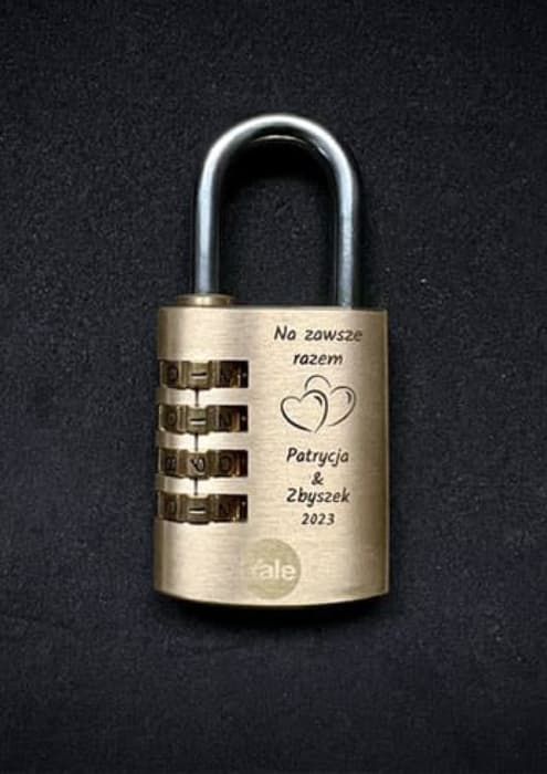 Grawerowanie prezentów na mosiężnej kłódce szyfrowej z imionami Patrycja i Zbyszek oraz datą.