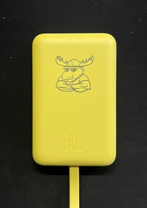 Znakowanie laserowe na żółtej plastikowej obudowie ładowarki z graficznym logo łosia.