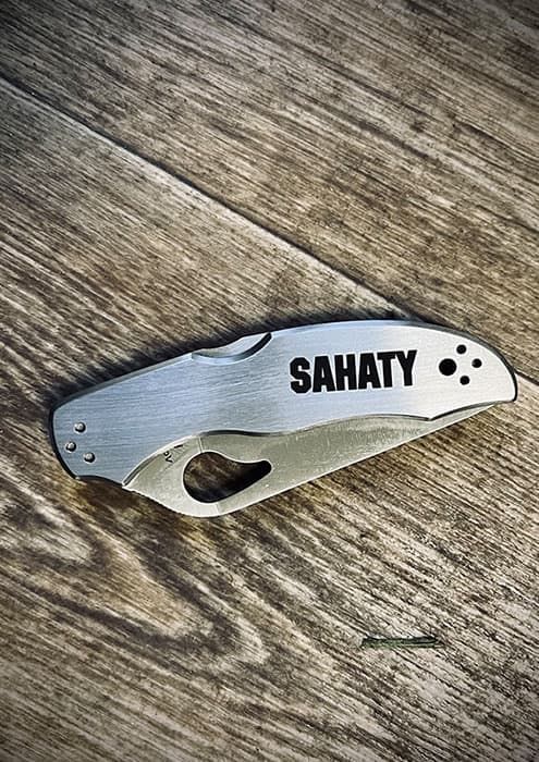 Grawerowanie laserowe dla firm na gadżetach – stalowy nóż składany z logo Sahaty.