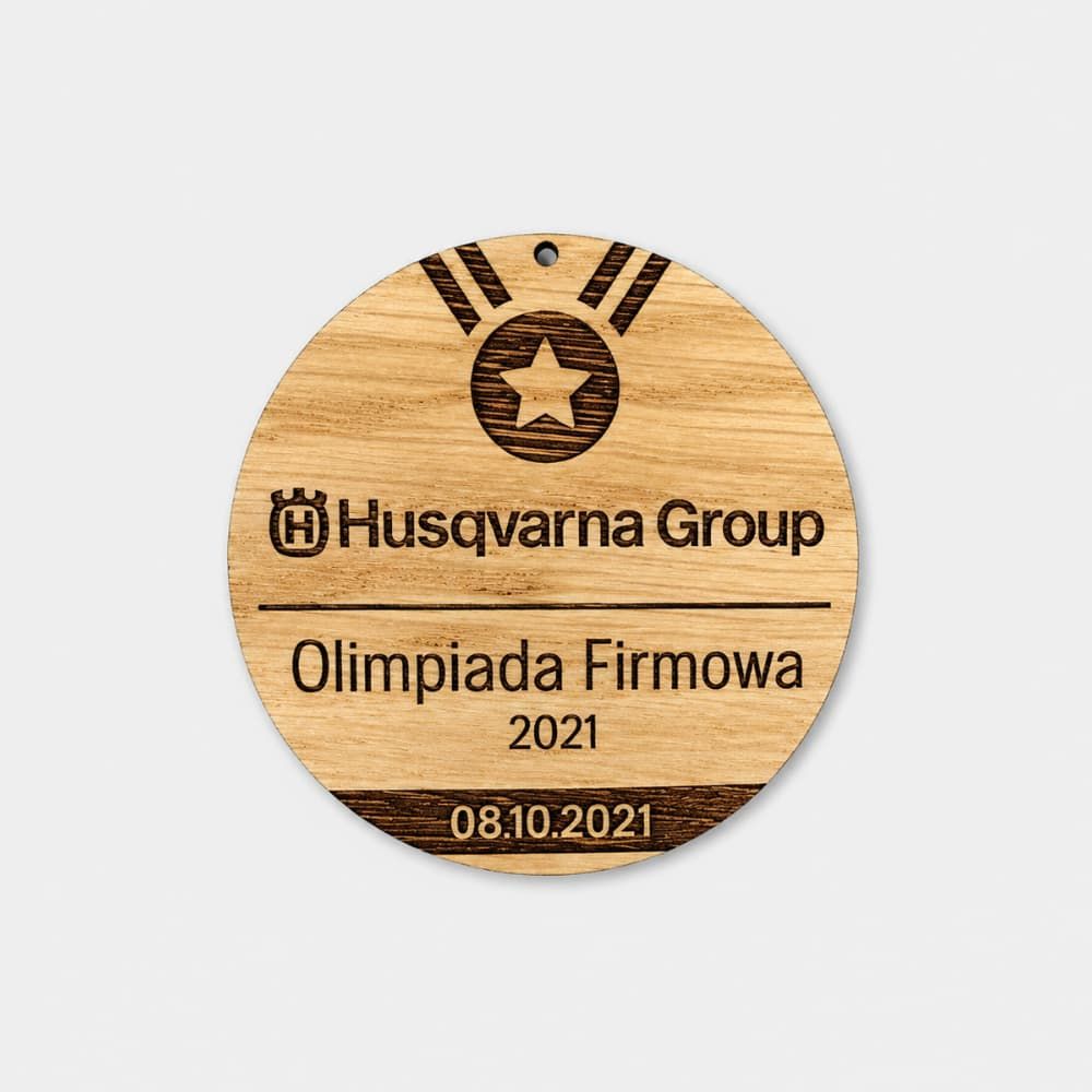 Okrągły drewniany medal z grawerem Husqvarna Group na olimpiadę firmową