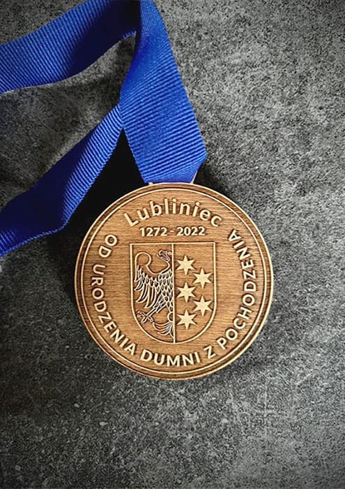 Medal z grawerowanym logo na drewnianym tle