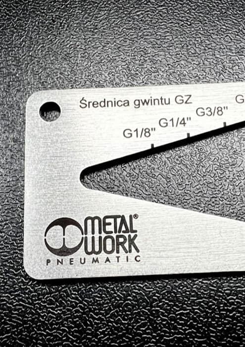 Stalowa miarka z czarnym logo firmy wykonanmy techniką grawerowania laserowego