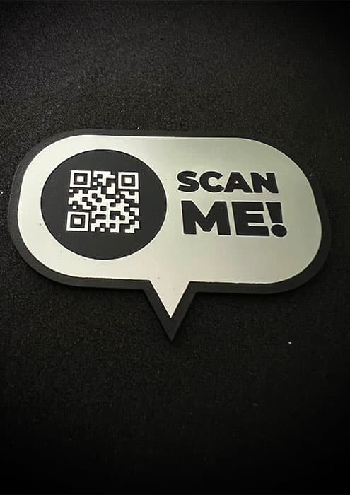 Tabliczka z wygrawerowanym kodem QR na eleganckim laminacie grawerskim.