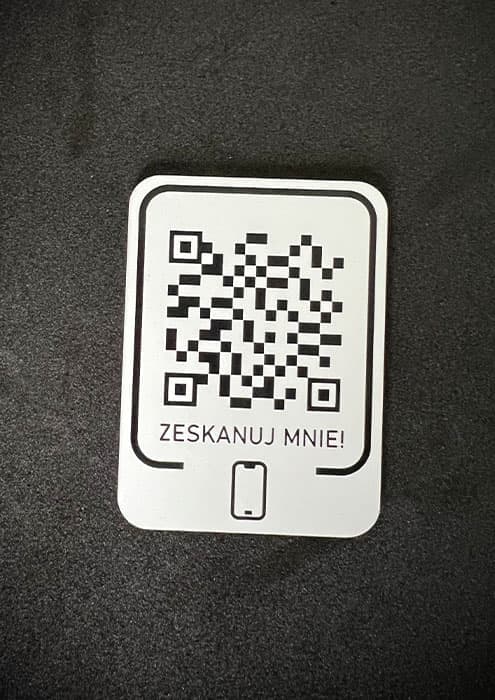 Precyzyjnie wygrawerowany kod QR na trwałej tabliczce z laminatu grawerskiego.