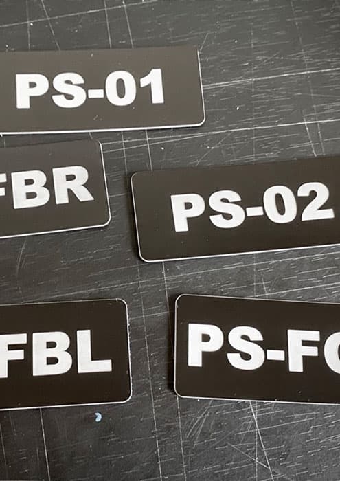 Tabliczka znamionowa samoprzylepna na urządzeniu pomiarowym, z opisem funkcji i zakresu pomiaru