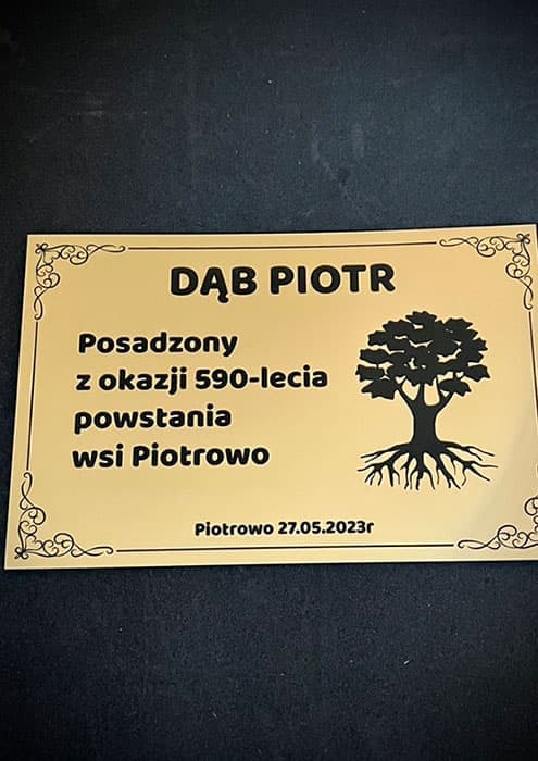 Ozdobna, metaliczna tabliczka pamiątkowa z motywem kwiatowym i grawerowanym tekstem na laminacie grawerskim